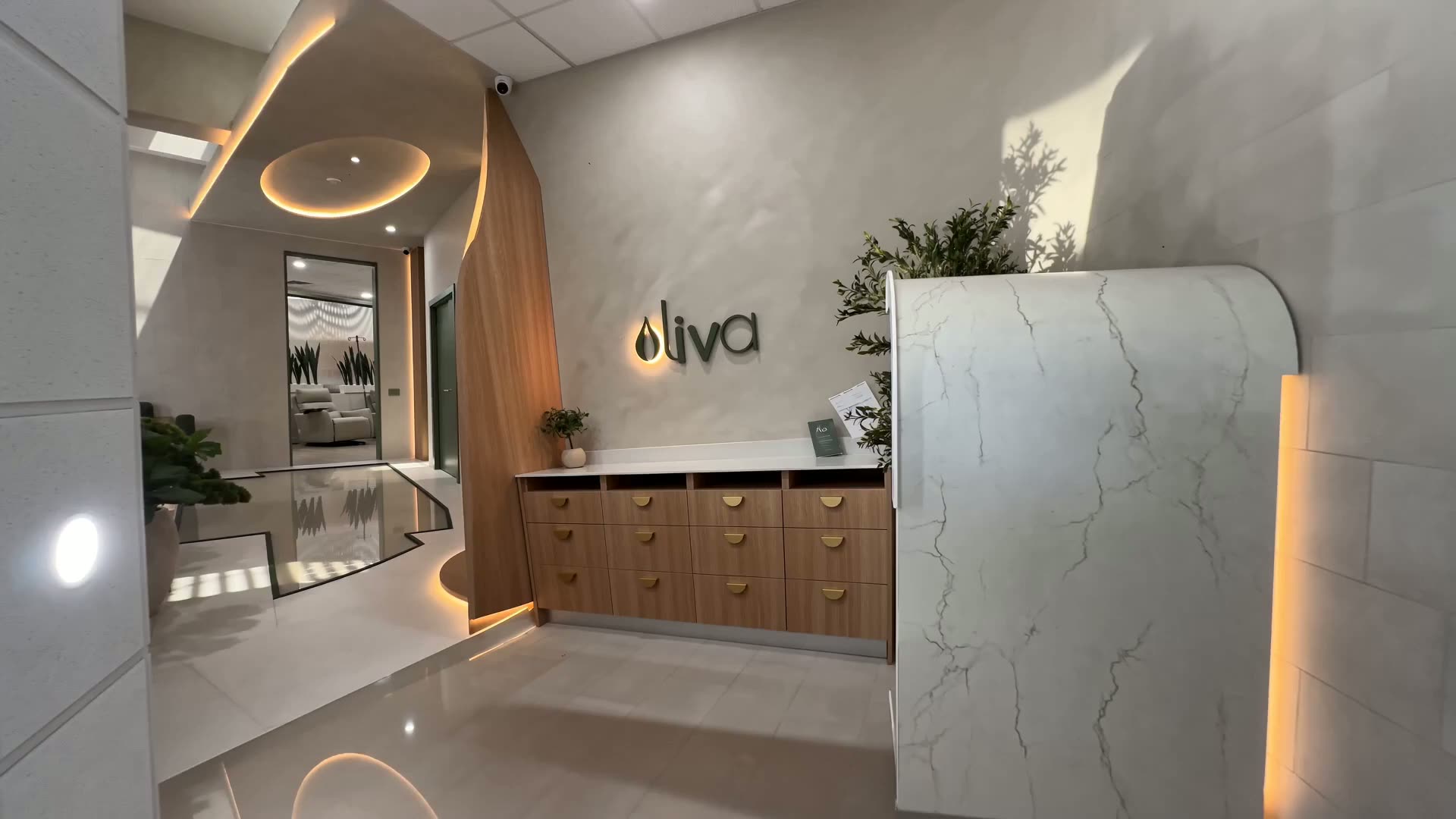 Recorrido por Oliva Wellness: recepción en mármol, letrero retroiluminado y sala de infusiones